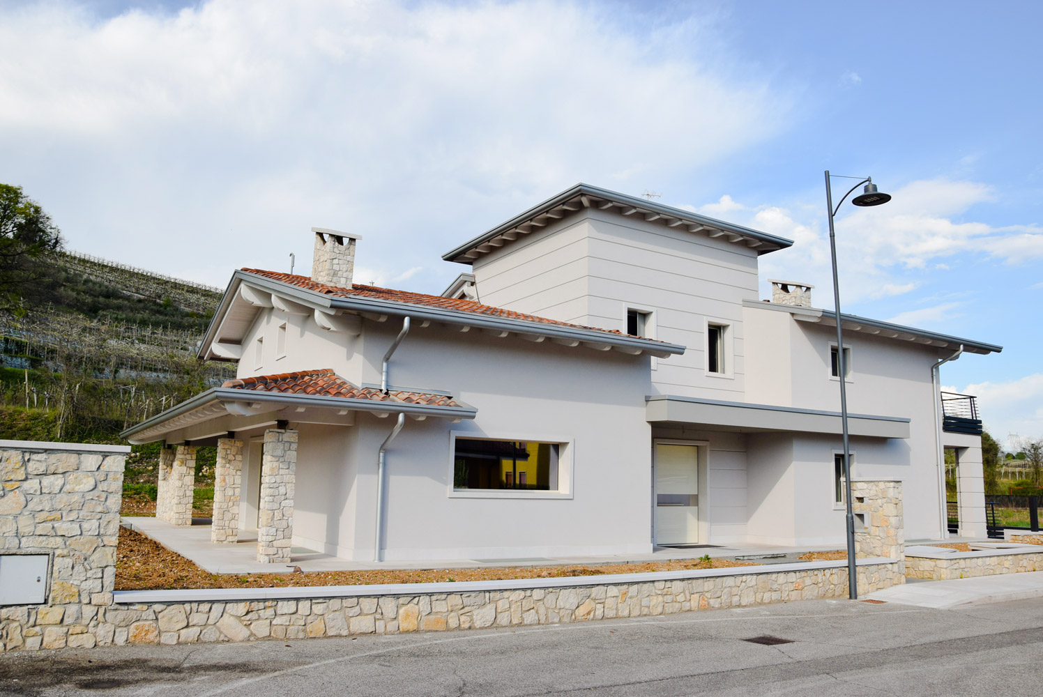 realizzazioni-residenziali-private-facciata-anteriore foto facciata esterna villa privata - L’edificio che ingloba le caratteristiche architettoniche tipiche della valpolicella, copertura a falde inclinate e grandi porticati in legno. studio tecnico ballarini e associati.